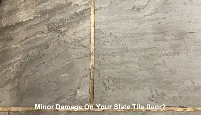 Localized slate floor damage beside stable surrounding tiles needing repair assessment